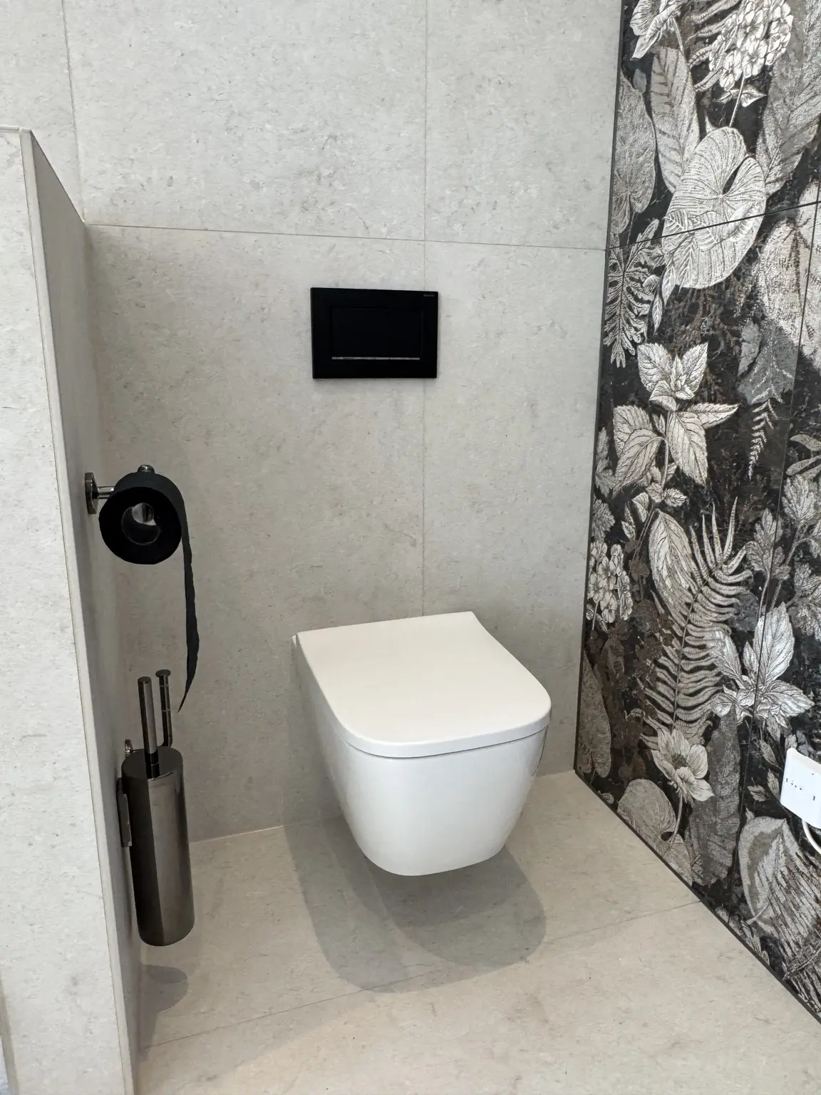 Modernes WC mit großformatigen Fliesen und Designwand